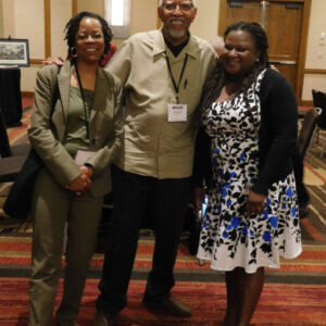 three people smiling at the camera