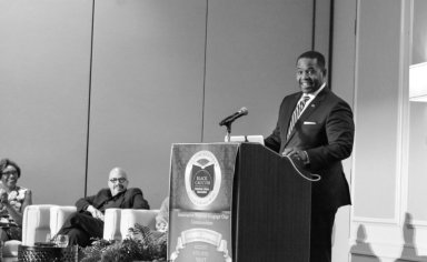 man speaking in front of people in seminar